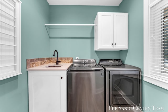 laundry area featuring independent washer and dryer, a sink, and cabinet space