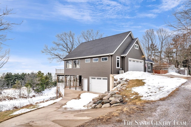 view of snow covered exterior with a garage and a carport