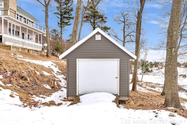 snow covered garage featuring a detached garage