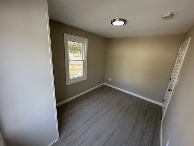 unfurnished room with baseboards and wood finished floors