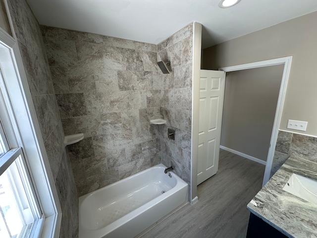 bathroom featuring shower / washtub combination, vanity, baseboards, and wood finished floors