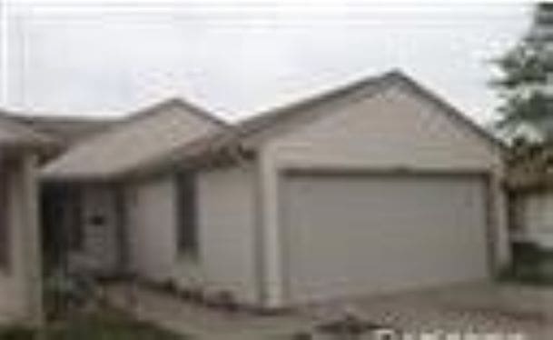 view of side of home with driveway and an attached garage