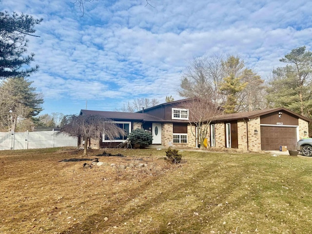 view of front of property with an attached garage, fence, and a front lawn