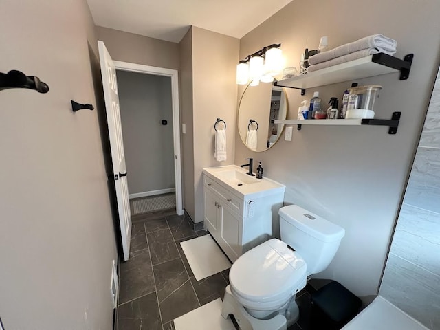 bathroom featuring vanity, toilet, and baseboards