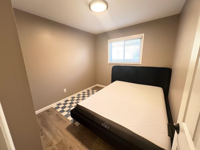 bedroom featuring baseboards and wood finished floors