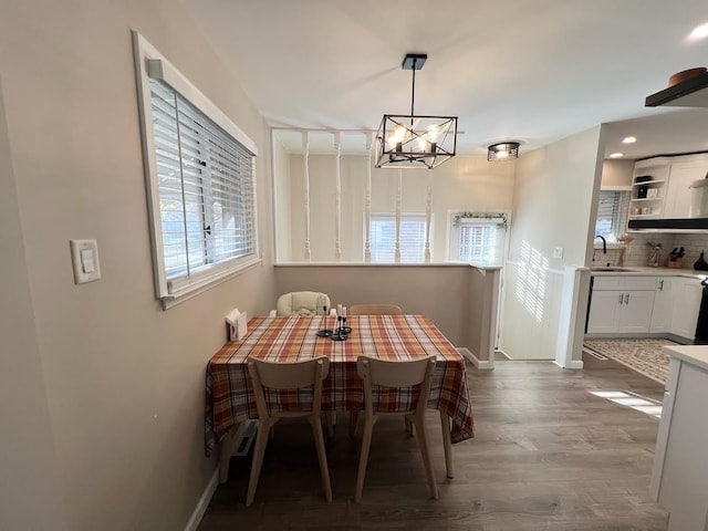 dining space featuring a chandelier, baseboards, and wood finished floors