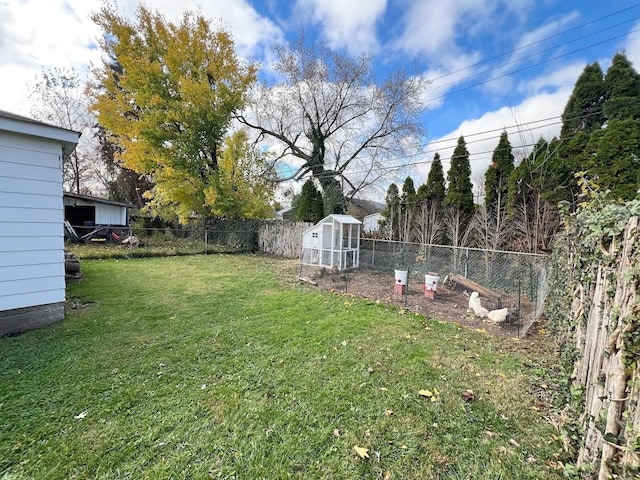 view of yard featuring an outbuilding, a fenced backyard, and exterior structure