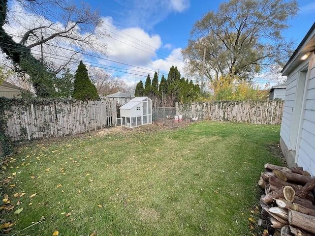 view of yard with a fenced backyard, an outdoor structure, and exterior structure