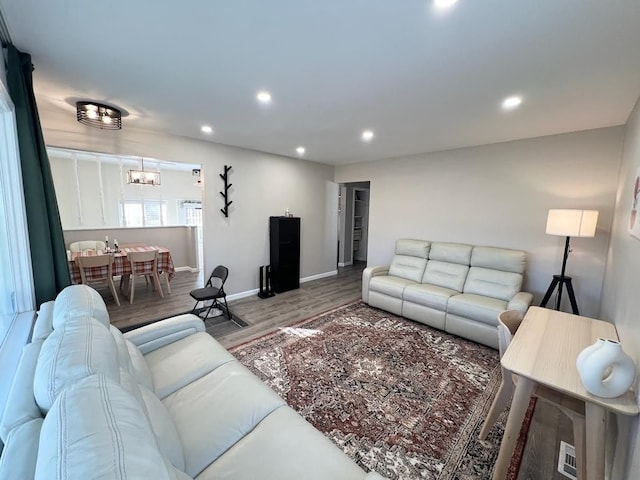 living area with baseboards, a chandelier, wood finished floors, and recessed lighting