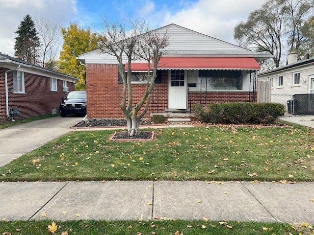 bungalow with a front lawn, concrete driveway, and brick siding