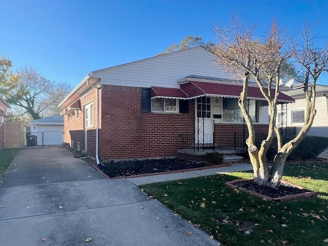 bungalow with brick siding, an outdoor structure, and a detached garage