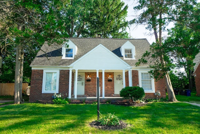 cape cod-style house with a porch, brick siding, fence, and a front lawn