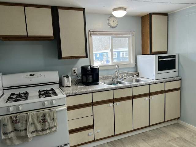 kitchen featuring a sink, light countertops, and gas range gas stove