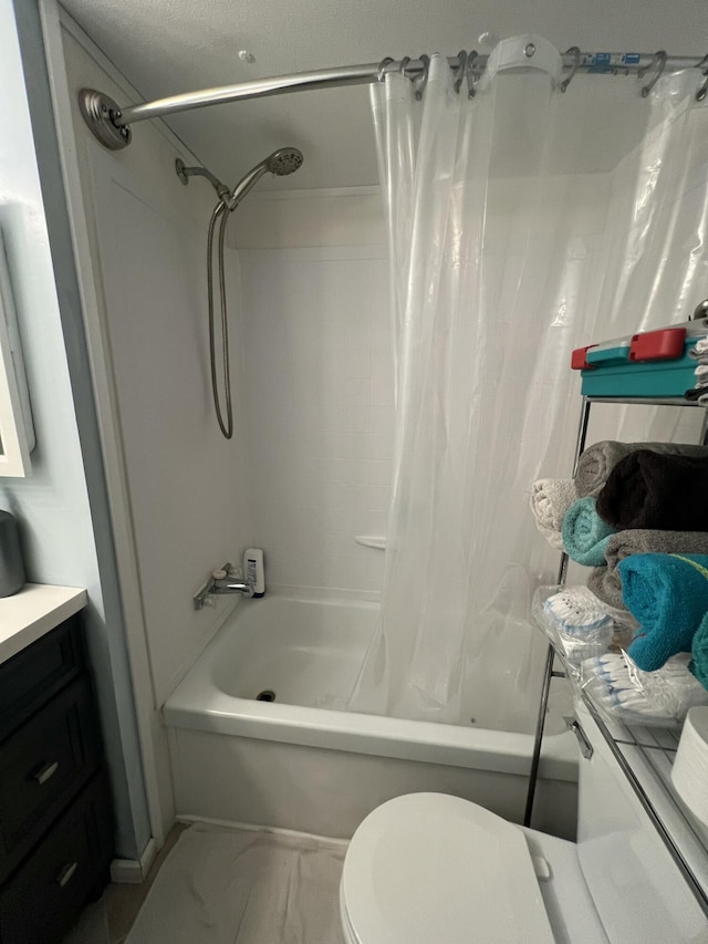 bathroom featuring marble finish floor, vanity, toilet, and shower / bath combo with shower curtain