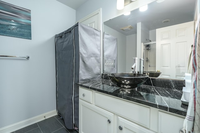 bathroom with visible vents, baseboards, a shower, tile patterned flooring, and vanity