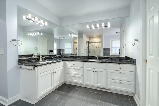 full bath with a stall shower, visible vents, a sink, and double vanity