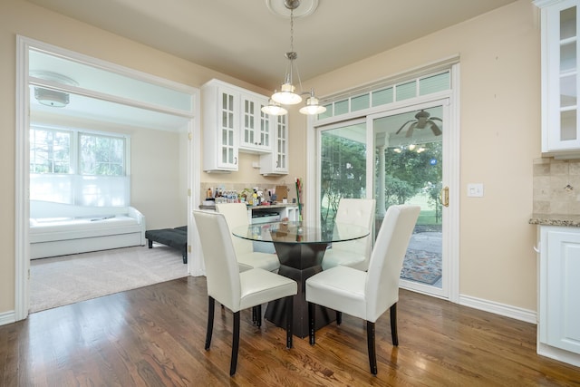 dining space with dark wood-style flooring and baseboards