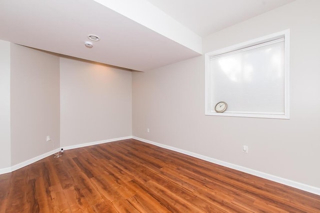 empty room featuring wood finished floors and baseboards