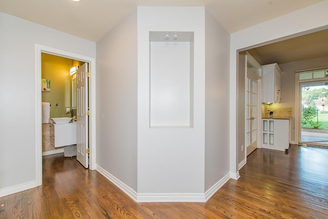 corridor with wood finished floors and baseboards