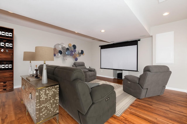 home theater with baseboards, wood finished floors, and recessed lighting