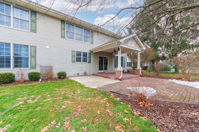 rear view of property featuring a yard and a patio