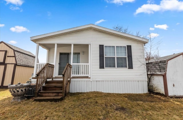 view of front facade with a storage shed, a porch, an outdoor structure, and a front yard