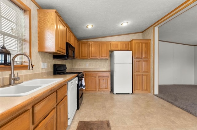 kitchen with a sink, vaulted ceiling, light countertops, black appliances, and crown molding