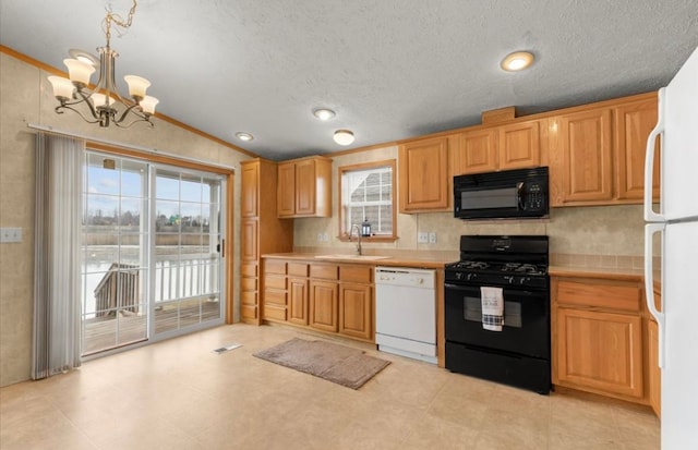 kitchen featuring light countertops, visible vents, vaulted ceiling, a sink, and black appliances