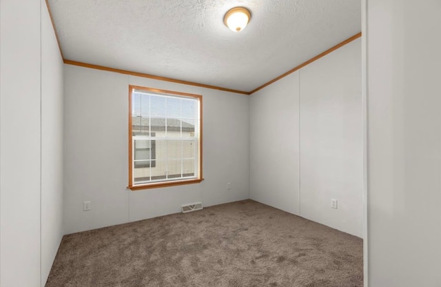 carpeted spare room with ornamental molding, visible vents, and a textured ceiling