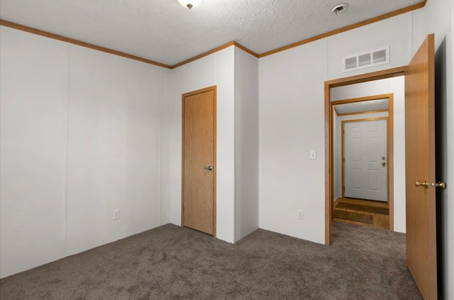 unfurnished bedroom with carpet floors, a textured ceiling, visible vents, and crown molding