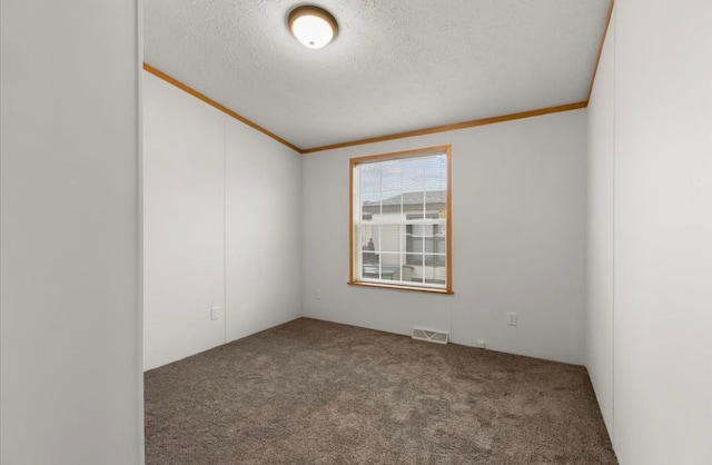 empty room featuring carpet floors, visible vents, a textured ceiling, and ornamental molding