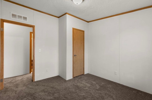 unfurnished room with crown molding, a textured ceiling, visible vents, and carpet flooring