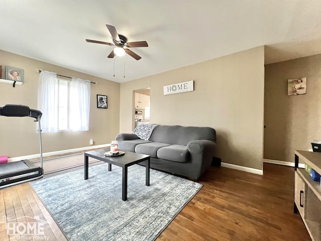 living area with ceiling fan, baseboards, and wood finished floors