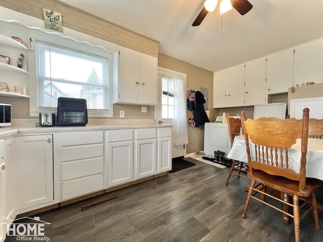 kitchen featuring washer / dryer, white cabinetry, light countertops, and dark wood-style flooring