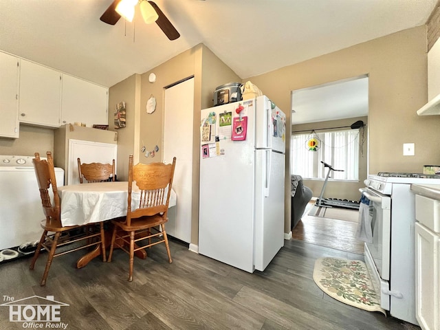 kitchen with white appliances, wood finished floors, white cabinetry, vaulted ceiling, and washer / clothes dryer