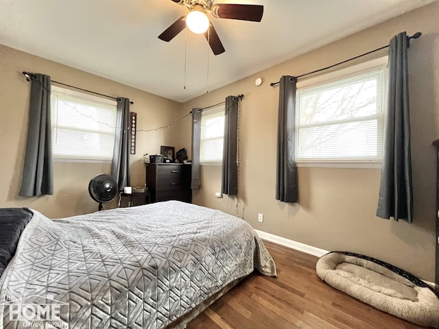 bedroom featuring wood finished floors, a ceiling fan, and baseboards