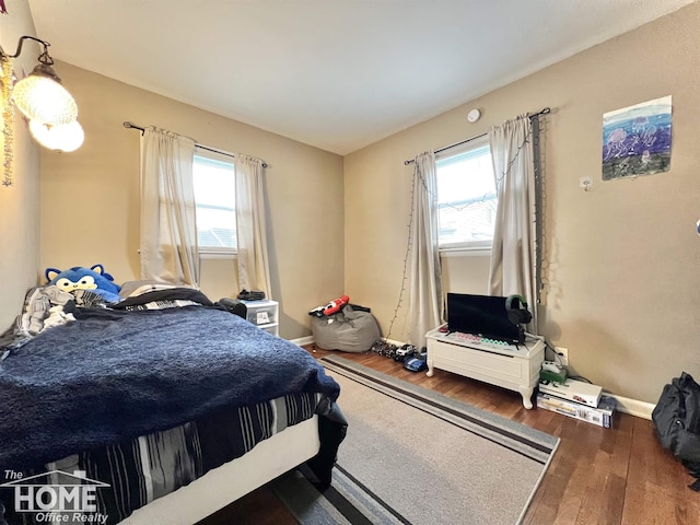 bedroom with baseboards and wood finished floors