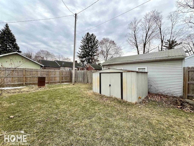 view of yard featuring a fenced backyard, an outdoor structure, and a storage unit