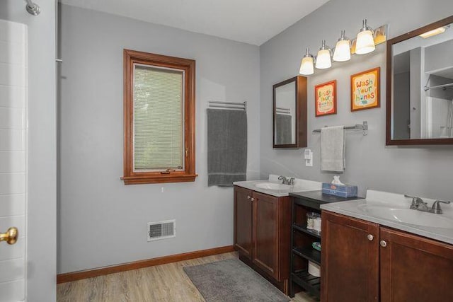 full bathroom featuring visible vents, a sink, baseboards, and wood finished floors