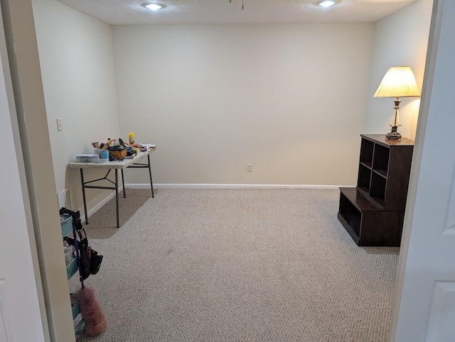 interior space with a textured ceiling and baseboards