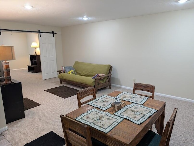 dining area featuring carpet floors, a barn door, and baseboards