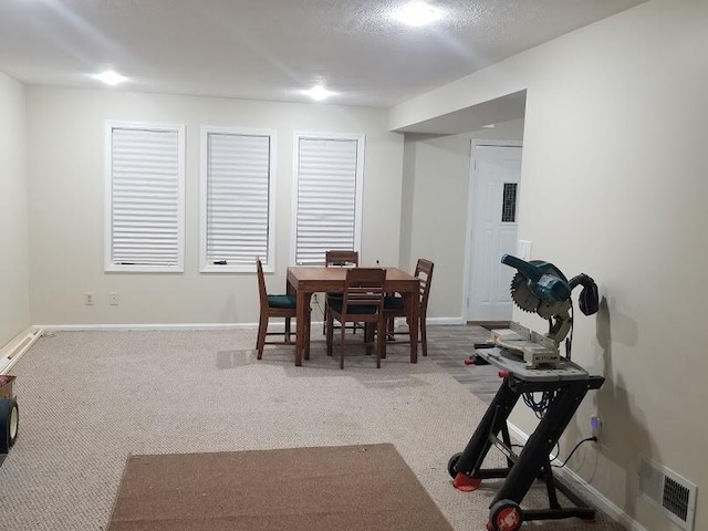 carpeted dining room with visible vents and baseboards