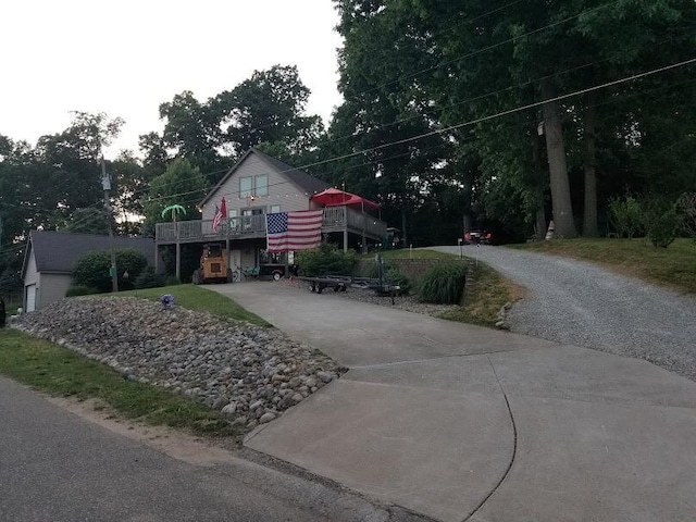 view of front facade featuring driveway and a deck