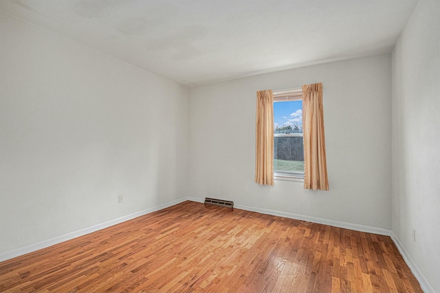 unfurnished room featuring visible vents, light wood-style flooring, and baseboards