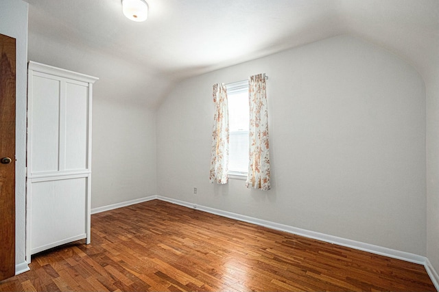 bonus room featuring lofted ceiling, baseboards, and wood finished floors