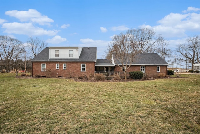 back of house with a yard and brick siding