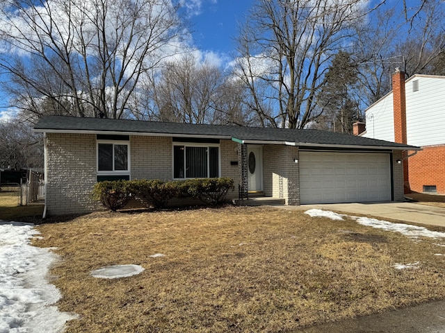 single story home with driveway, brick siding, and an attached garage