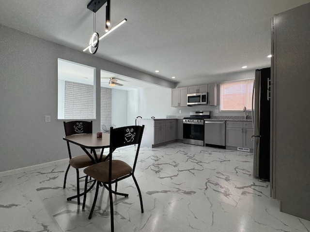 dining area with marble finish floor, ceiling fan, a textured ceiling, and baseboards