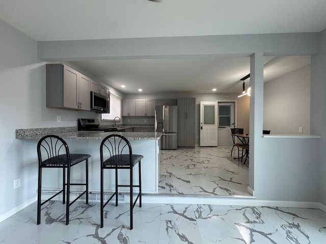 kitchen featuring gray cabinetry, a peninsula, baseboards, marble finish floor, and appliances with stainless steel finishes