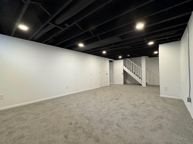 finished below grade area with carpet floors, stairway, and baseboards